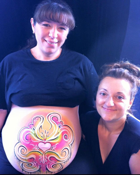 Melissa posing with a prenatal belly painting client in Ottawa.
